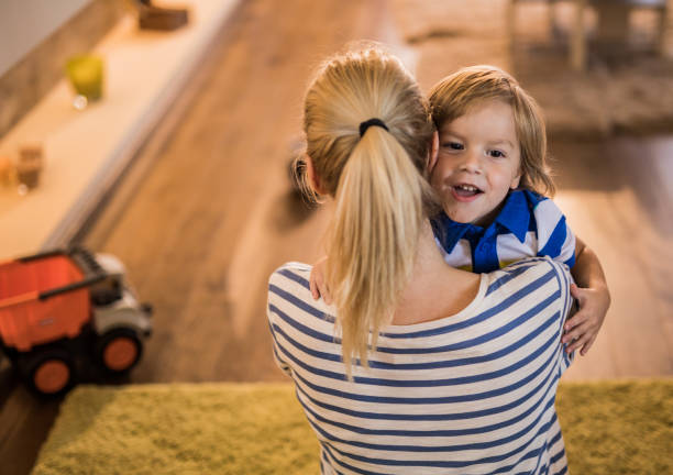 istock Happy little boy embracing his mother at home. 962136568