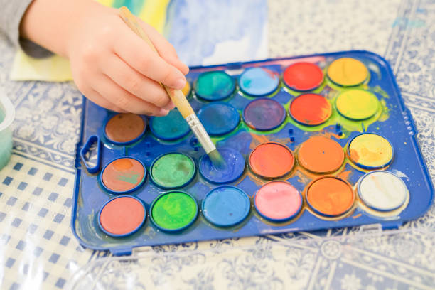 istock Child painting with water colour paints 962139444