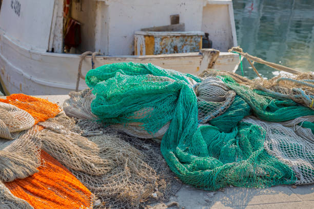 istock Fishing nets piled on the quay in a harbor 962139958