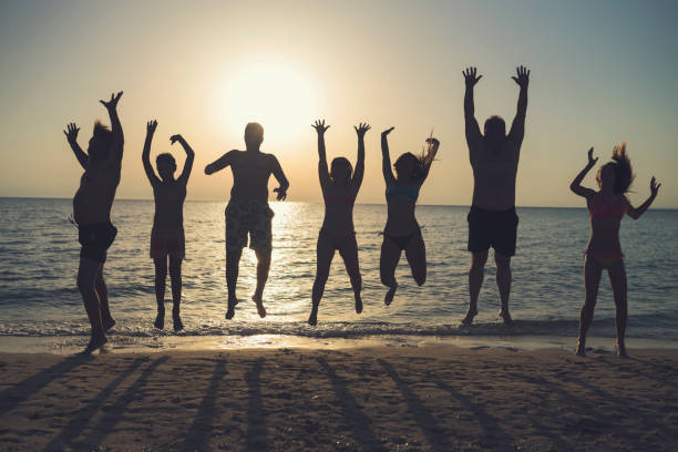 istock People jumping on the beach in the evening 962140530