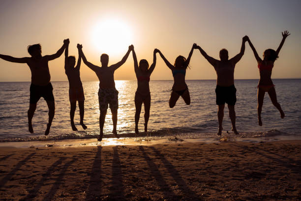 istock People jumping on the beach in the evening 962140636