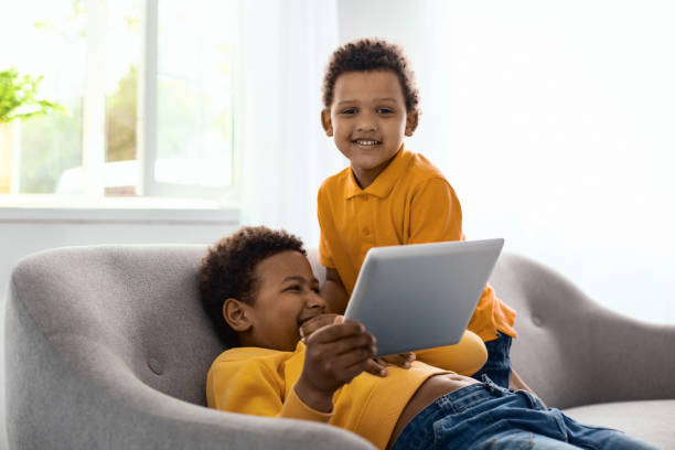 istock Cheerful little boy posing while watching cartoon with brother 962142026