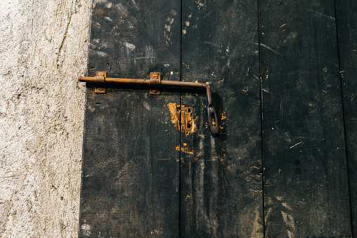 Close up view of iron lock on an weathered wooden door.