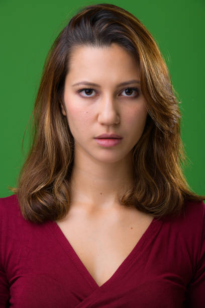 istock Young beautiful multi-ethnic woman against green background 962146564