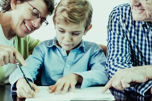 istock Diligent Grandson Doing Homework With Grandparents 962147046
