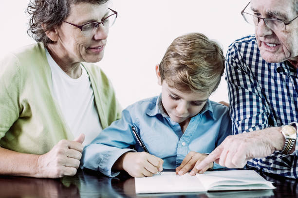 istock Senior Grandparents Teaching Grandson to Write 962147134