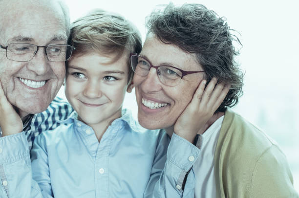 istock Smiling Little Boy Embracing Grandparents 962147148