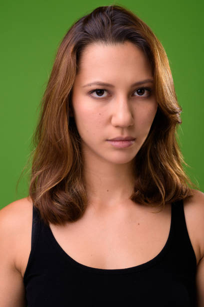 istock Young beautiful multi-ethnic woman against green background 962147166