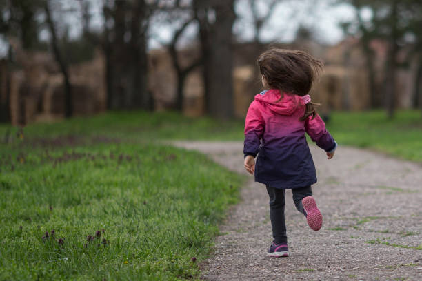 istock Little girl having fun, running in park 962147812