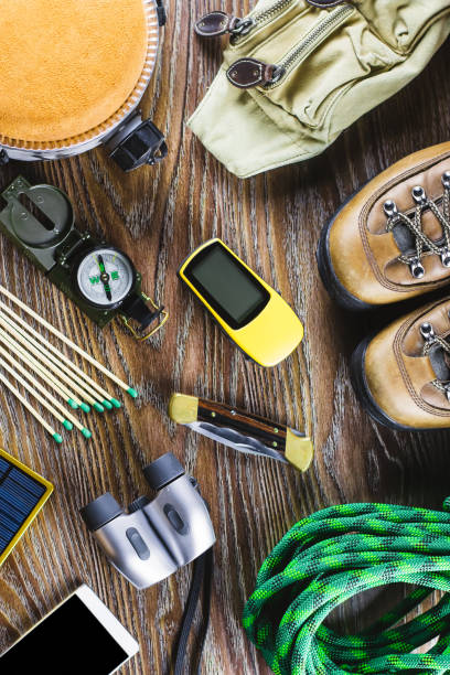 istock Hiking or travel equipment with boots, compass, binoculars, matches on wooden background. Active lifestyle concept 962155700