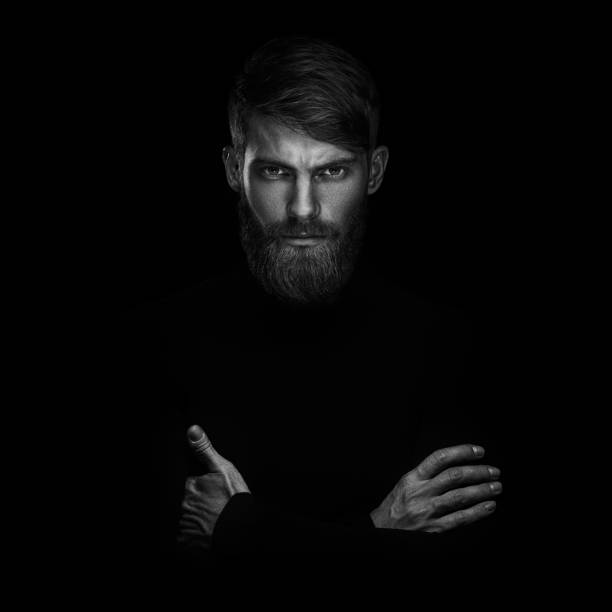 Portrait of serious young man with arms folded standing isolated