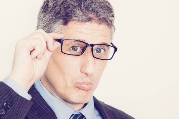 istock Upset middle-aged businessman grimacing face and looking at camera. Confused manager adjusting eyeglasses. He received bad news. Gray-haired man pursing lips. Irony concept 962156554