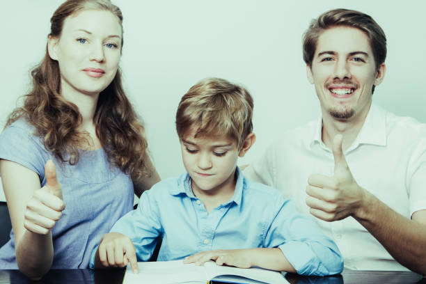 istock Mom, Dad and Son Reading Book With Thumbs Up 962156660