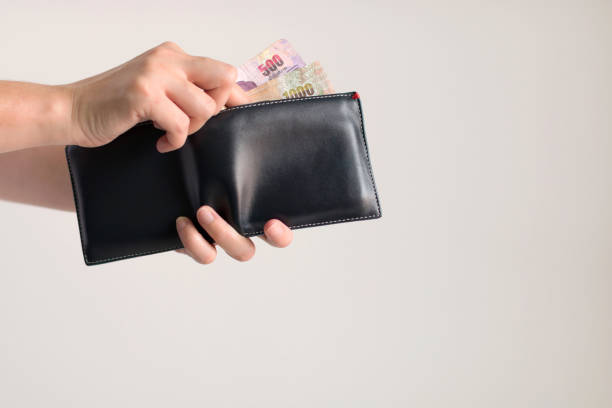 istock Hands picking money in Thai baht from wallet for paying. 962156948