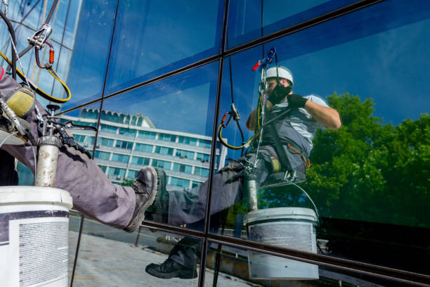 istock Industrial climber at work, cleaning facade of a modern office building 962157922