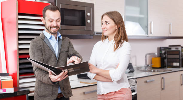 istock Salesman offering female client material for kitchen furniture 962158042