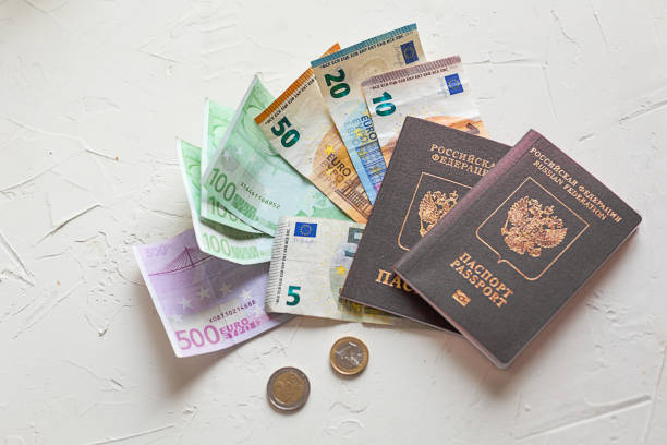 istock Several euros on white concrete table, passports and coins. 962158408