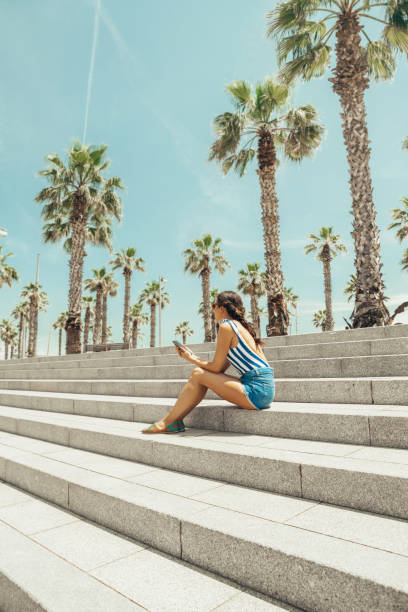 femme regardant la plage de barceloneta - shorts rear view summer beach photos et images de collection