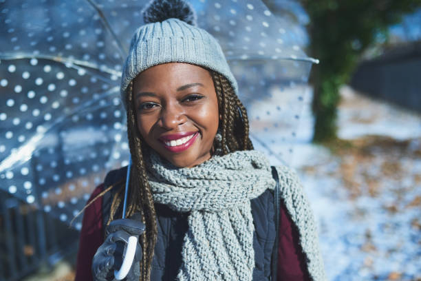 Shot of a beautiful young woman holding an umbrella on a wintery day outdoors