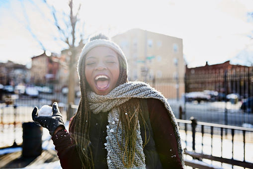 Shot of a beautiful young woman throwing a snowball on a wintery day outdoors