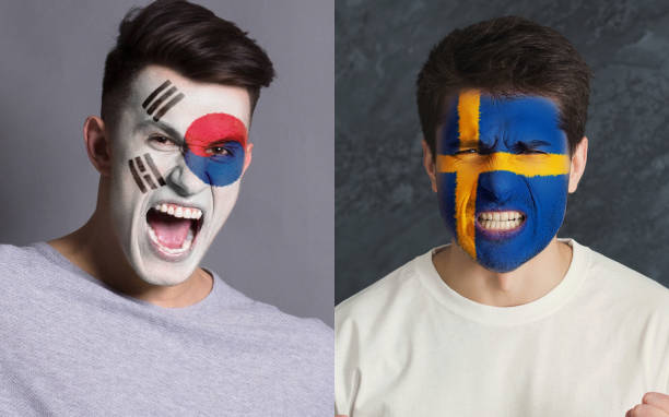 istock Emotional soccer fans with painted flags on faces 962174384