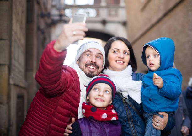 istock Mom and dad with their small kids doing selfie 962174476