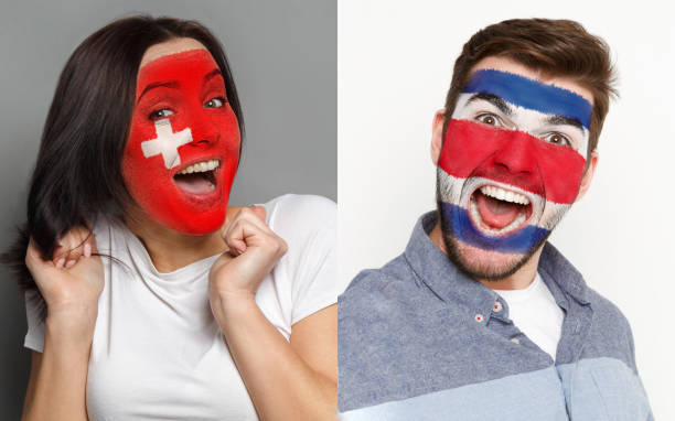 istock Emotional soccer fans with painted flags on faces 962174656