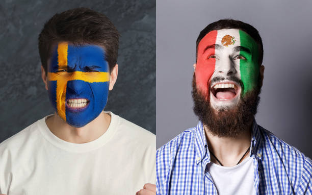 istock Emotional soccer fans with painted flags on faces 962174678