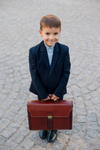istock Smiling future businessman in formal costume with briefcase 962177524