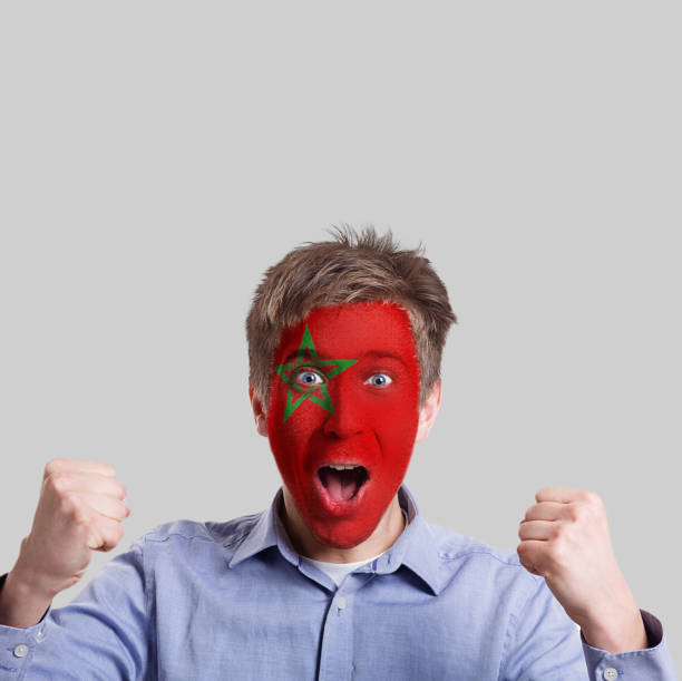 istock Young man with Morocco flag painted on his face 962178716