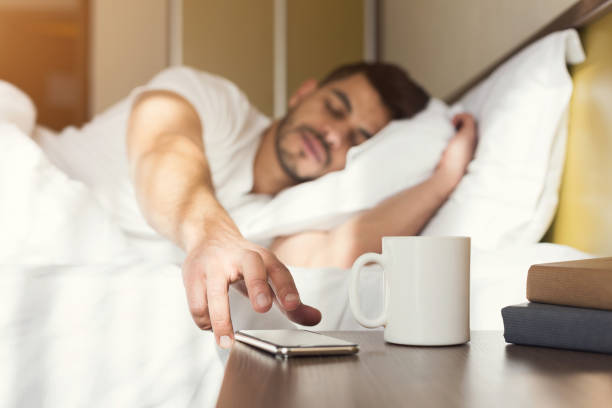 sleepy guy réveiller tôt après le signal de réveil - hotel wireless technology bedroom hotel room photos et images de collection