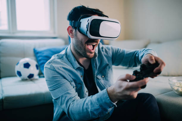 hombre emocionado jugando juegos de realidad virtual - videojuego fotos fotografías e imágenes de stock