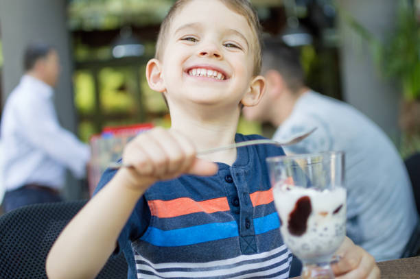 istock Little boy eating ice cream at restaurant 962193108