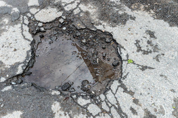 istock Large rounded pothole filled with water in Montreal 962197072