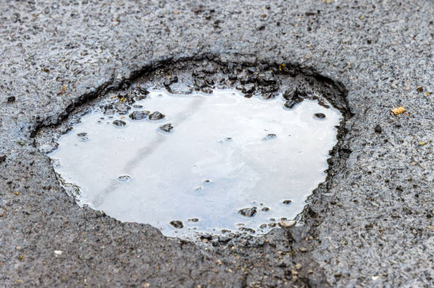 istock Large rounded pothole filled with water in Montreal 962197744