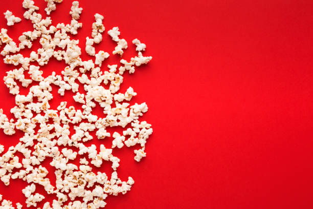 istock Slaty popcorn scattered on red background, top view 962197910
