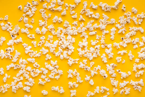 istock Slaty popcorn scattered on yellow background, top view 962198356
