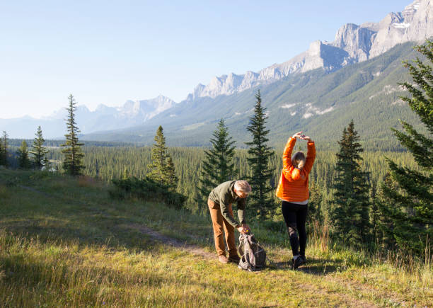 Hiking couple follow trail through mountain meadow