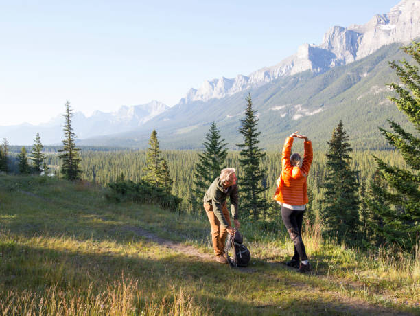 istock Hiking couple follow trail through mountain meadow 962202872