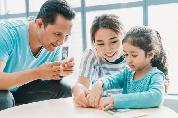 istock Happy family looking at instant prints together 962203228
