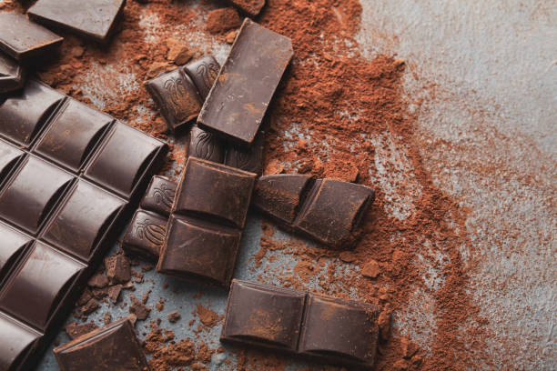 istock Crushed chocolate bar pieces and cocoa on gray background 962203670