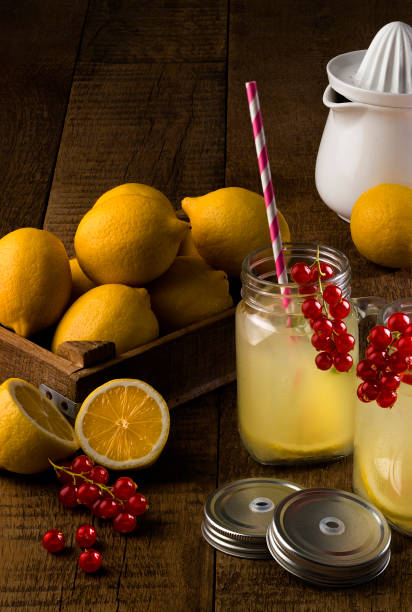 Fresh lemonade, redberry, lemon with squezzer on wooden table