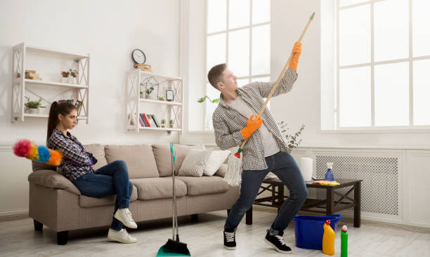 istock Young couple cleaning home, playing with mop 962209632
