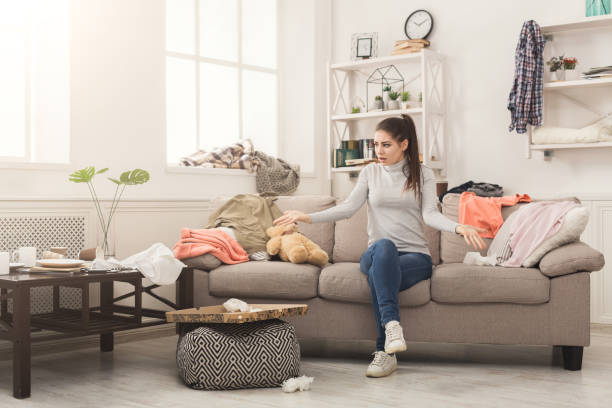 istock Desperate woman sitting on sofa in messy room 962210342