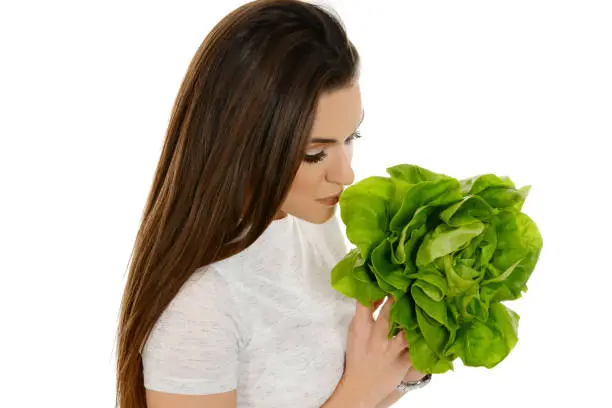 Beautiful woman with lettuce isolated on white background