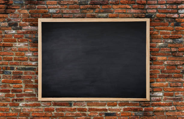 istock Old wooden photo frame on blackboard And Black brick wall for background. texture for add text. 962215080
