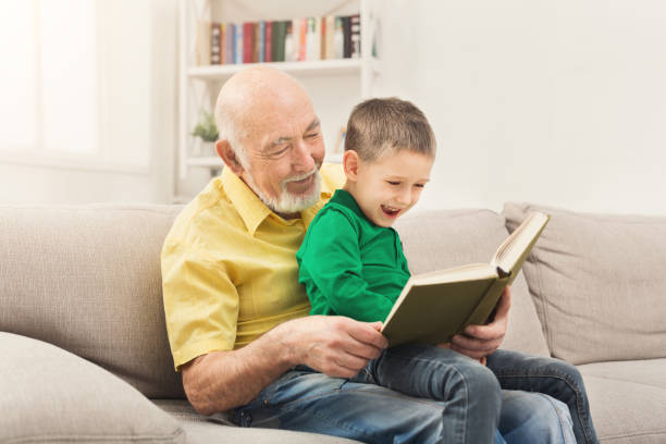 istock Senior man reading book for his grandchild 962219404