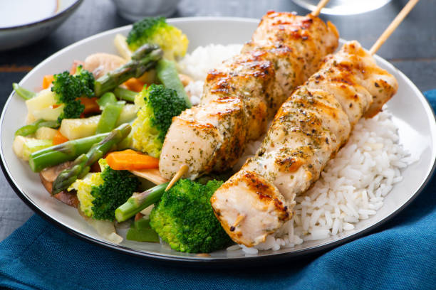 istock Chicken skewers with steamed vegetables and long rice 962219530