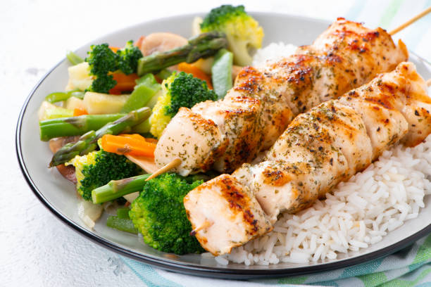 istock Chicken skewers with steamed vegetables and long rice 962219584