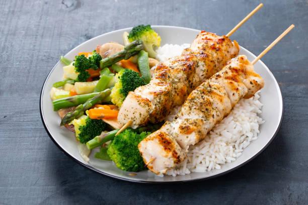 istock Chicken skewers with steamed vegetables and long rice 962219728